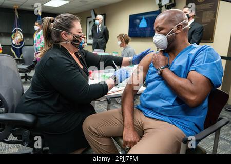 Nurse vaccinator Denise Boehm somministra un vaccino COVID-19 allo staff dell'esercito degli Stati Uniti Sgt. Marvin Cornish durante un briefing sul processo di vaccinazione con il presidente Joe Biden lunedì 8 marzo 2021, presso il Washington DC Veterans Affairs Medical Center di Washington, D.C. (Official White House Photo by Adam Schultz) Foto Stock