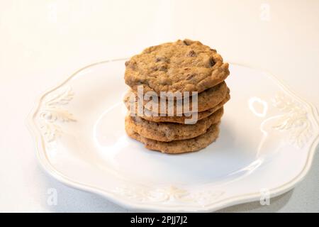 Una pila di cinque biscotti fatti in casa con scaglie di cioccolato o biscotti su un piatto bianco. STATI UNITI. Foto Stock