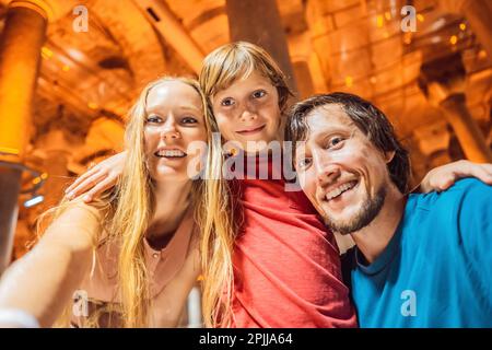 Padre, madre e figlio turisti che godono di bella cisterna a Istanbul. Cisterna - serbatoio di acqua sotterranea costruito nel 6th ° secolo, Istanbul, Turchia Foto Stock