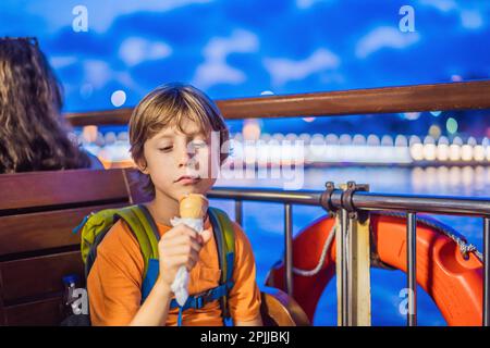 Ragazzo turistico che mangia gelato turco in traghetto nel Bosforo. Concetto di viaggio con i bambini Foto Stock