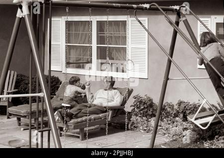 ST-C387-9-63 10 novembre 1963 il presidente John F. Kennedy visita il figlio John F. Kennedy Jr. Nella residenza della famiglia Kennedy, Wexford, ad Atoka, Virginia. Caroline Kennedy sale sull'altalena a destra. Si prega di accreditare 'Cecil Stoughton. Fotografie della Casa Bianca. John F. Kennedy Presidential Library and Museum, Boston' Foto Stock