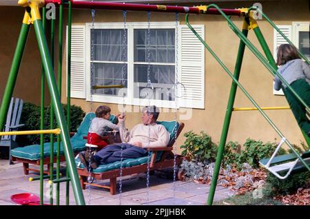 ST-C387-9-63 10 novembre 1963 il presidente John F. Kennedy visita il figlio John F. Kennedy Jr. Nella residenza della famiglia Kennedy, Wexford, ad Atoka, Virginia. Caroline Kennedy sale sull'altalena a destra. Si prega di accreditare 'Cecil Stoughton. Fotografie della Casa Bianca. John F. Kennedy Presidential Library and Museum, Boston' Foto Stock
