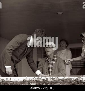 ST-C267-1-63 14 agosto 1963 il presidente John F. Kennedy visita il suo padre, l'ambasciatore Joseph P. Kennedy, Sr., nel portico della sua casa presso il complesso Kennedy di Hyannis Port, ma. Anche nella foto: infermiera, nipote Ann Gargan (estrema destra). Si prega di accreditare 'Cecil Stoughton. Fotografie della Casa Bianca. John F. Kennedy Presidential Library and Museum, Boston' Foto Stock