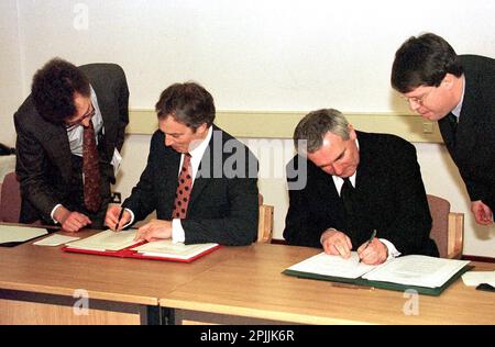 Foto del file datata 10/04/98 dell'allora primo ministro Tony Blair (a sinistra) e poi del Taoiseach Bertie Ahern che firmano l'accordo di pace del Venerdì Santo, in cui si affermava che il popolo dell'Irlanda del Nord deciderà democraticamente il proprio futuro. A Blair è stato consigliato di utilizzare la "macchina del governo” per chiedere il sì nel referendum sull'accordo del Venerdì Santo, ma non nella misura in cui rischierebbe di mettere in discussione il risultato della votazione storica. Sir Tony Blair e Bertie Ahern hanno salutato lo spirito di collaborazione anglo-irlandese che ha segnato il negoziato ad alta pressione Foto Stock