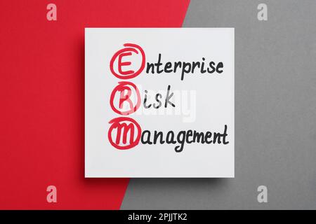 Carta con abbreviazione ERM e relativa interpretazione (Enterprise Risk Management) su sfondo a colori, vista dall'alto Foto Stock