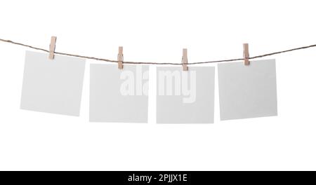 Clothespins con i notepapers vuoti sul filo contro lo sfondo bianco. Spazio per il testo Foto Stock