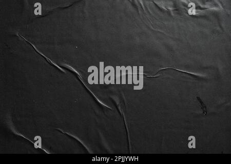 Carta nera incollata su una parete Foto Stock