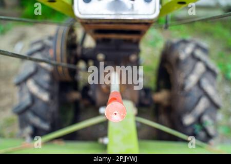 Leva del cambio su un trattore con operatore a distanza ravvicinata su uno sfondo sfocato. Elementi di controllo di macchine agricole. Collegamento rototiller e cambio marcia Foto Stock