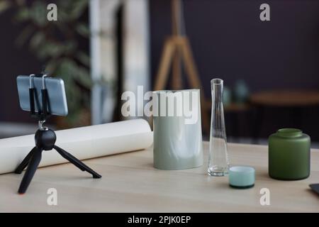 Posto di lavoro di artigiani con smartphone su treppiede e gruppo di vasi artigianali diversi pronto per la ripresa masterclass casa Foto Stock