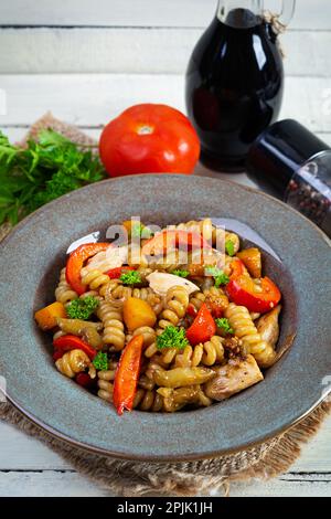 Pasta con pollo fritto, funghi, pepe e zucca Foto Stock