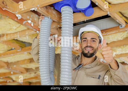 Tecnico di impianti di termoventilazione pronto per installare il sistema di ventilazione in casa Foto Stock