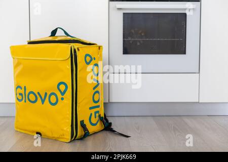 KIEV, UCRAINA - Marzo 19 2023: Glovo Thermal giallo sacchetto alimentare isolato su sfondo bianco. Mockup per azienda di consegna di alimenti. Concetto di ordinazione del cibo Foto Stock