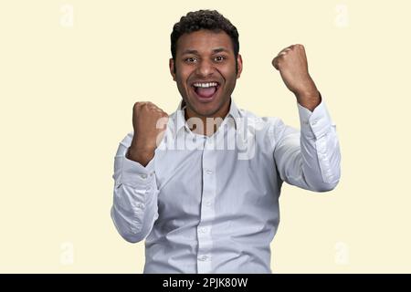 Il ragazzo indiano eccitato o arabo gioisce nel successo. Isolato su sfondo bianco. Foto Stock