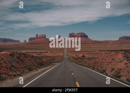 Vista della Monument Valley da Forrest Gump Point Mexican Hat, US-163 con strada che conduce ai monumenti. Cielo blu e giorno di sole. Foto Stock