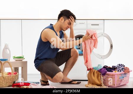 Ritratto di un giovane stanco che fa il bucato Foto Stock