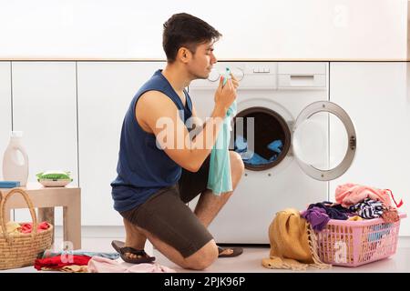 Ritratto di giovane uomo che fa il bucato Foto Stock