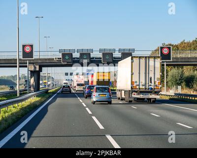 Segnaletica stradale, segnaletica per i limiti di velocità e segnaletica a matrice di corsie con frecce verdi sull'autostrada A1, Paesi Bassi Foto Stock