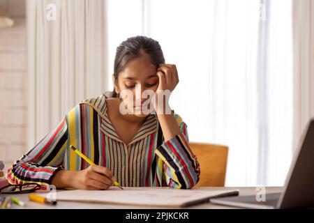 Bambina che fa la sua classe online utilizzando il notebook a casa Foto Stock