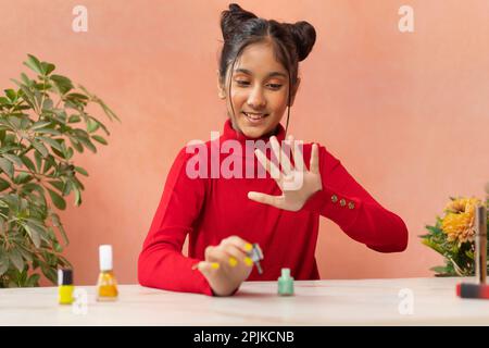 Ritratto di una ragazza di Tween che dipinge le unghie delle dita Foto Stock