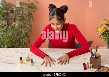 Ritratto di una ragazza di Tween che dipinge le unghie delle dita Foto Stock