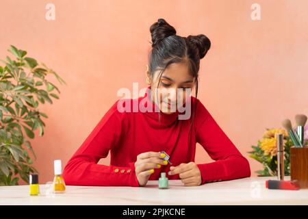 Ritratto di una ragazza di Tween che dipinge le unghie delle dita Foto Stock