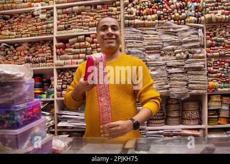 Ritratto di un allegro custode del negozio in piedi presso la sua negozio di merletti Foto Stock