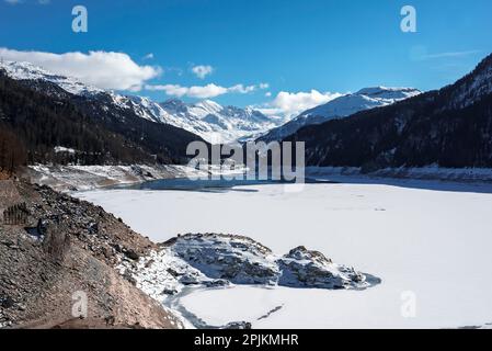 Vista panoramica del lago ghiacciato tra le montagne con il cielo sullo sfondo Foto Stock