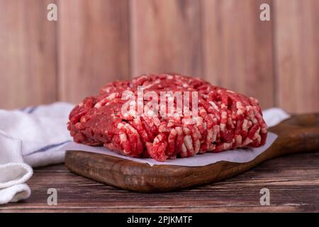 Carne macinata su sfondo di legno. Carni di vacca macinate crude o macinate Foto Stock