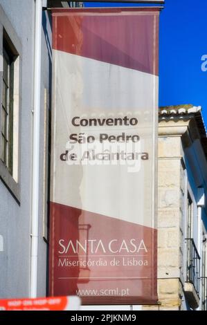 Lisbona, Portogallo - 4 gennaio 2023: Vista da basso angolo di una bandiera rossa e bianca attaccata al lato di un edificio. Si legge Convento Sao Pedro de Alcanta Foto Stock
