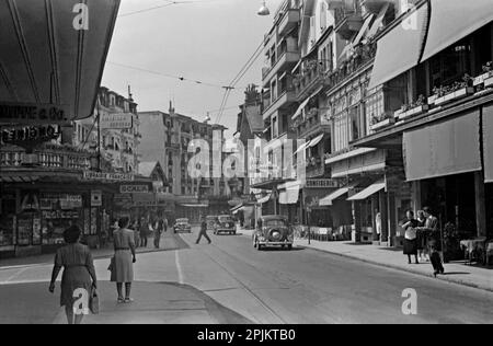 Una vista lungo Avenue du Casino, Montreux, Svizzera nel 1949. Questa vista si affaccia verso est su Rue Igor Sravinsky. Le auto d'epoca sono poche e la strada molto tranquilla rispetto ad oggi. Si noti che l'immagine Alamy 2PJKTB7 è la stessa strada vista nella direzione opposta. A volte la strada è indicata come Avenue du Kursaal. Questo è il risultato di un vecchio amatoriale in bianco e nero 35mm negativo – una fotografia del dopoguerra vintage. Foto Stock