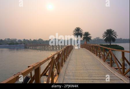 Ponte di legno sul lago. Impostazione SEN in background. Foto Stock