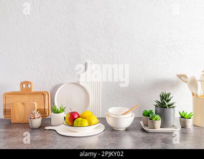 Bella cucina sfondo con un set di vari piatti ecologici, taglieri, frutta in una ciotola. spazio per il testo Foto Stock