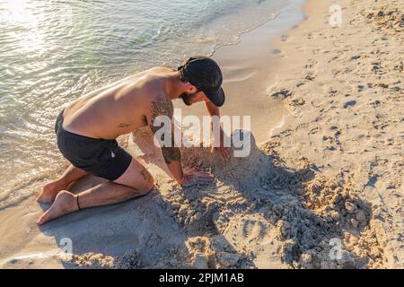 Playa Balandra, la Paz, Baja California sur, Messico. Uomo costruendo sculture di sabbia sulla spiaggia di Balandra. (Solo per uso editoriale) Foto Stock