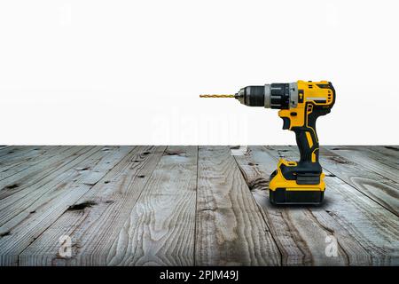 Trapano elettrico o cacciavite cordless con batteria per lavori professionali su sfondo in legno. Foto Stock