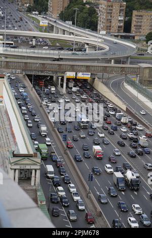 Vista sul traffico intenso sull'autostrada a più corsie (ingorghi); inoltre, grande rotatoria sopraelevata Foto Stock