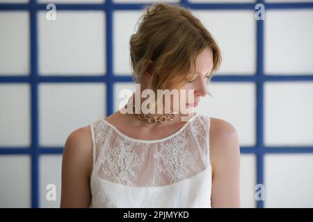 Ritratto di moda di donna in pizzo bianco top di fronte alle tradizionali finestre in stile greco blu Foto Stock