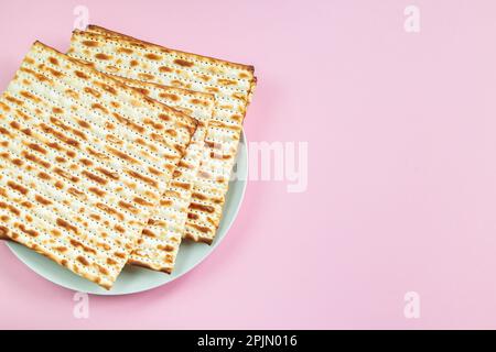 Tradizionale cibo ebraico pane matzo su sfondo rosa. Buona Pasqua. Vacanza religiosa primaverile Pesach. Spazio di copia. Foto Stock