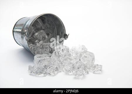 secchio di ghiaccio sul suo lato con ghiaccio versato isolato su uno sfondo bianco. Foto Stock
