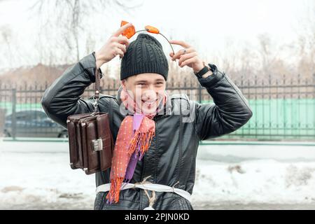 Un giovane allegro con le orecchie della tigre sulla sua testa ride mentre guarda la macchina fotografica. Celebrazione di Maslenitsa. 22 febbraio 2015, Kolomna, Mosca reg Foto Stock