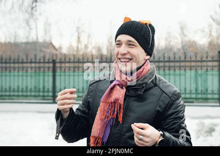 Un giovane allegro con le orecchie della tigre sulla sua testa ride mentre guarda la macchina fotografica. Celebrazione di Maslenitsa. 22 febbraio 2015, Kolomna, Mosca reg Foto Stock