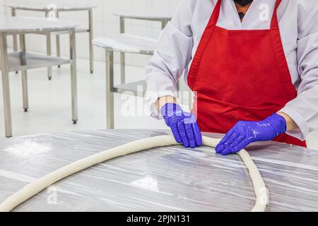 Processo di preparazione di tradizionale pasto bosniaco chiamato 'burek'. Pasta bosniaca tradizionale, manti borek con carne macinata (kiymali). Nome turco; Bosnak ma Foto Stock