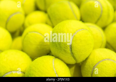 un sacco di palline da tennis gialle come sfondo. primo piano Foto Stock