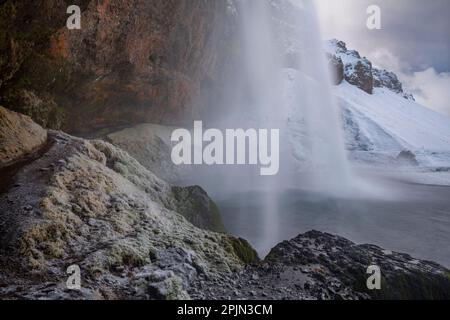 Vista di Seljalandsfoss dall'interno della cascata in una bella giornata invernale, l'Islanda. Foto Stock
