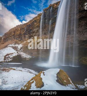 Vista di Seljalandsfoss dall'interno della cascata in una bella giornata invernale, l'Islanda. Foto Stock
