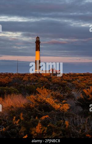 Una vista panoramica di un faro in lontananza, sullo sfondo di nuvole scure Foto Stock