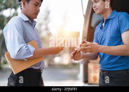 Operatore logistico che consegna scatole di cartone al destinatario alla porta di casa. Eseguire la scansione del codice QR. concetto di consegna pacchi tramite corriere Foto Stock