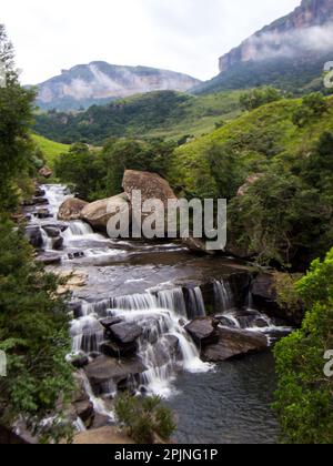 Bianco e nero vista mattutina delle cascate di Mahai, con le montagne Drakensberg avvolte nella nebbia sullo sfondo Foto Stock