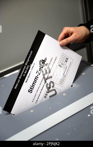 03 aprile 2023, Brema: Un campione di uno scrutinio per l'elezione al Parlamento di Brema viene gettato in una cassa di voto presso l'Istituto statistico di Stato. Quasi 463.000 persone possono votare alle elezioni del parlamento di Brema del 14 maggio. L'invio di notifiche elettorali inizia il 4 aprile. Foto: Sina Schuldt/dpa Foto Stock