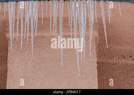 Ghiaccioli sul tetto. Lo scarico è pieno di neve e ghiaccio. Ghiaccio cadere concetto di pericolo. Foto Stock