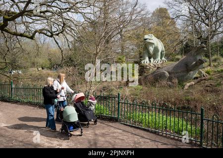 I visitatori possono ammirare le sculture di dinosauri, patrimonio dell'umanità dell'epoca vittoriana di grado i, a Crystal Palace Park, il 3rd aprile 2023, a Londra, in Inghilterra. Crystal Palace Park ha ricevuto £304.000 dal National Lottery Heritage Fund per contribuire al miglioramento e al restauro della sua “isola dei dinosauri”, dove 30 pterodattili, un megalosauro e sculture di iguanodoni sono stati creati solo 10 anni dopo la coniazione del termine “dinosauro”, E sette anni prima che Charles Darwin pubblicasse la sua teoria dell'evoluzione. Foto Stock